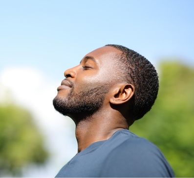 African American man tips his head back and takes a deep breath