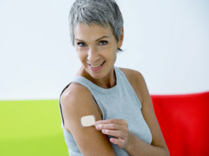 woman applying a BHRT patch post hysterectomy