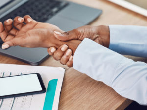 woman holding wrist to illustrate mixed type of pain like carpal tunnel syndrome