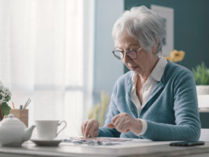 senior woman at desk doing a puzzle for cognitive health
