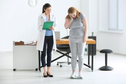 young-female-doctor-measuring-weight-of-overweight-woman-in-clinic