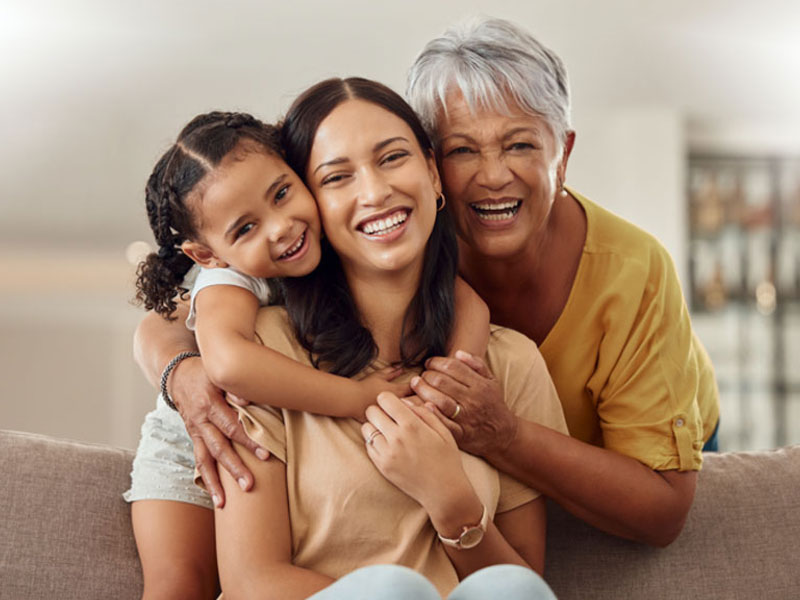 grandmother,mum, and child hug to illustrate late menopause linked to longevity
