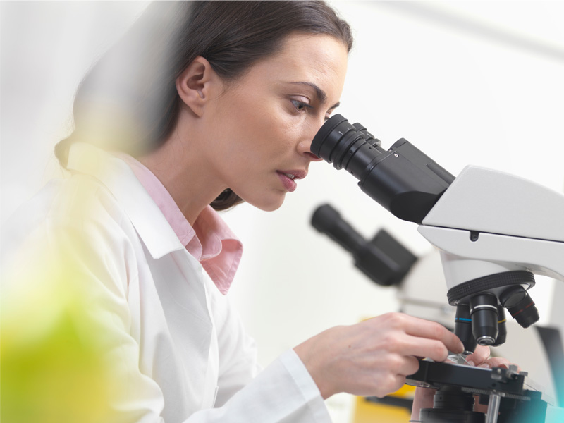 scientist using microscope to illustrate diagnostic testing in longevity medicine