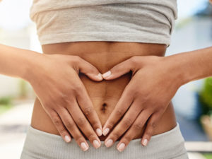 hands on gut area to illustrate the need to recognize an imbalance in your microbiome